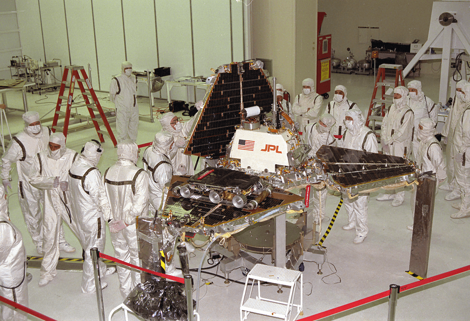 A month before launch, a group of JPL engineers check how the solar panels fold