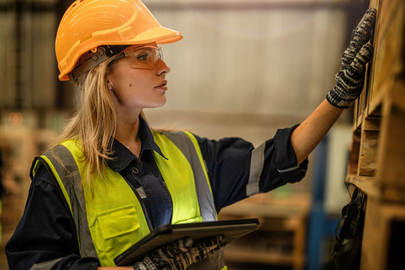 A warehouse worker using AR smart glasses and a tablet to streamline inventory tracking and order picking