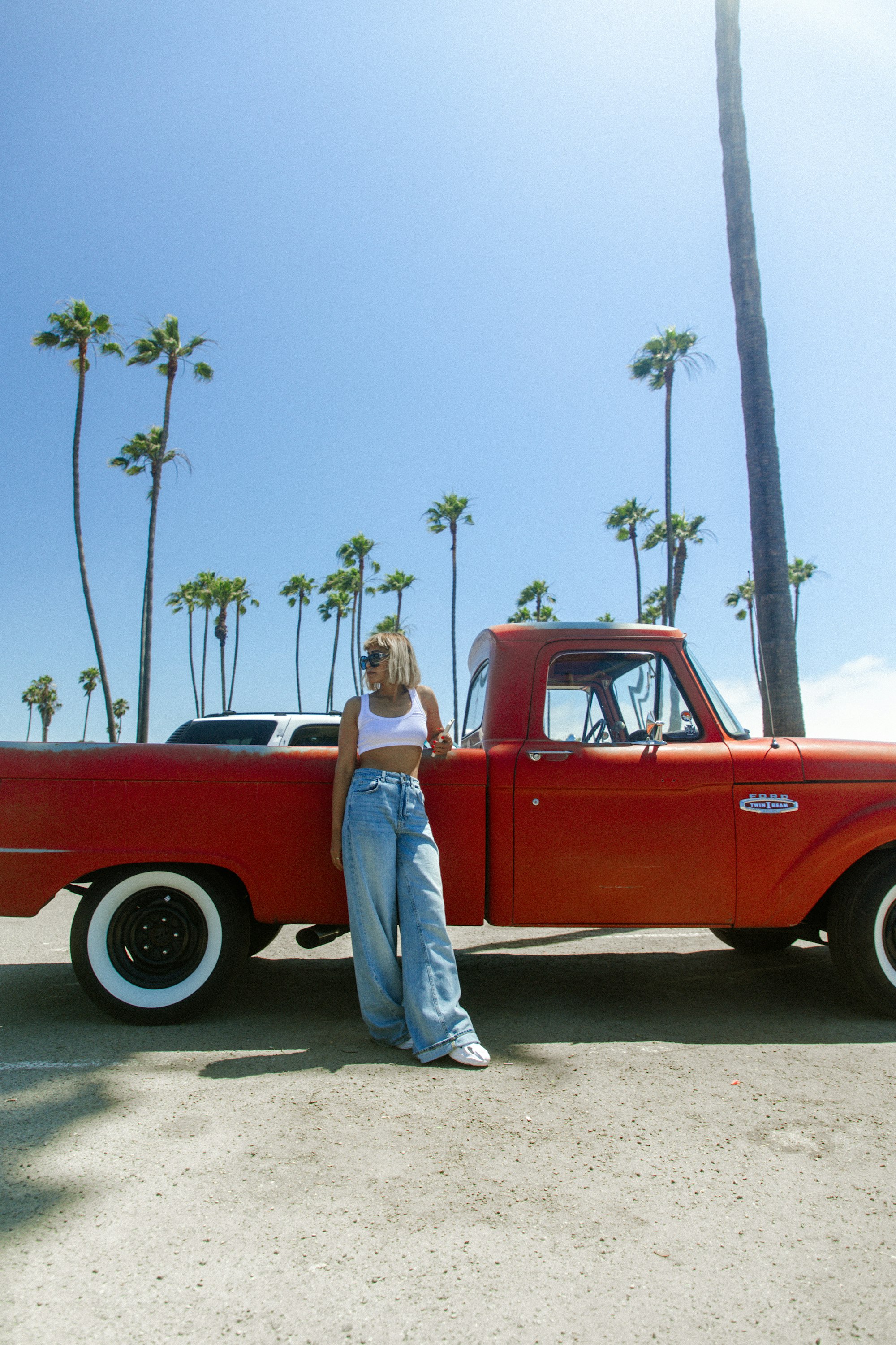 a woman standing next to a red truck - Photo by Pawan Thapa / Unsplash