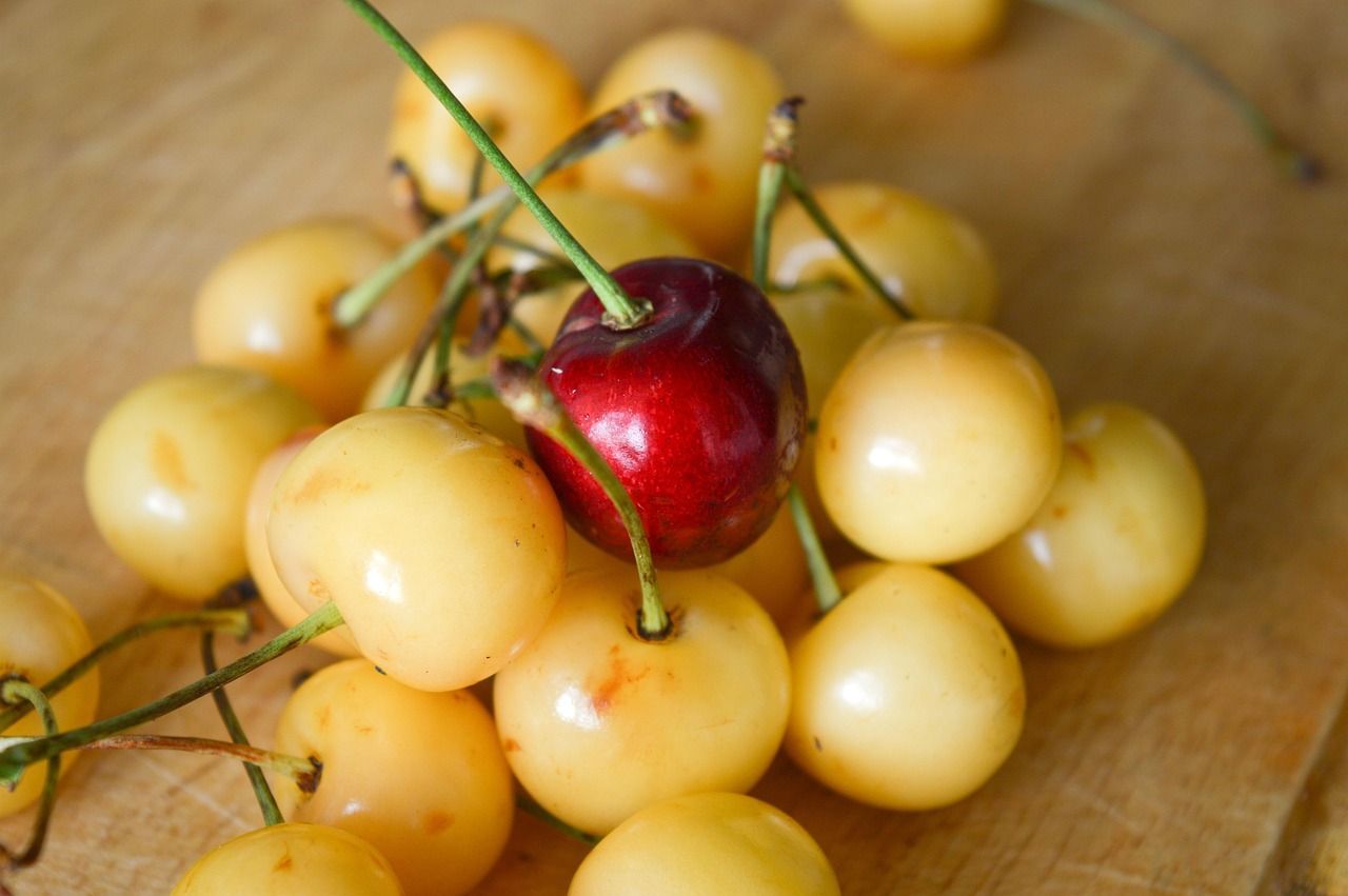 one red cherry in a bunch of white cherries