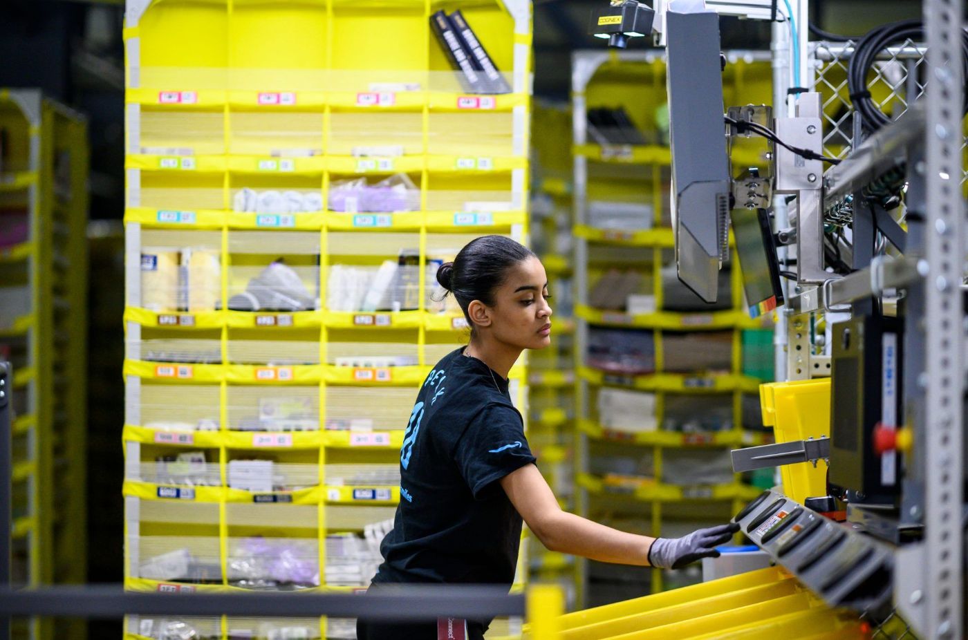 Amazon warehouse worker at fulfillment center floor - Image Credits: